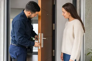 Chaveiro realizando a abertura de uma porta com ferramentas apropriadas.